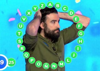 Hombre con barba y manos en la cabeza en un concurso televisivo rodeado de un aro de letras verdes, El sueldo de Puigdemont: cifras impactantes que no conocías