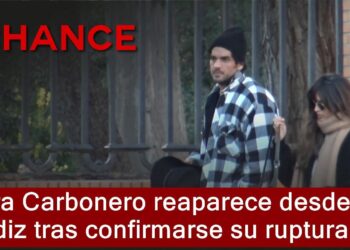 Descubre dónde vive Sara Carbonero y su refugio personal: una pareja abrigada pasea frente a una reja metálica y una pared de ladrillo bajo un titular rojo.