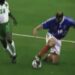 Jugador de fútbol en acción disputando el balón en césped durante un partido
