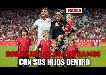 Familia y varios niños posando en el césped de un estadio con un titular sensacionalista en rojo sobre un supuesto robo