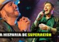 Cantante en escena con micrófono y expresión de emoción y superación