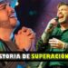 Cantante en escena con micrófono y expresión de emoción y superación