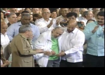 Grupo de hombres en un acto público, uno recibe un saludo entre aplausos y miradas en una sala multitudinaria; Los hijos de Aznar: secretos y lujos de su vida actual