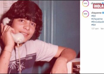Joven sonriente sosteniendo un teléfono blanco en una fotografía retro