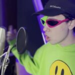 Joven con gorra y gafas coloridas frente a un micrófono en un estudio casero, Dónde vive Spreen: descubre la casa del streamer argentino más popular