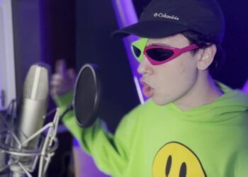 Joven con gorra y gafas coloridas frente a un micrófono en un estudio casero, Dónde vive Spreen: descubre la casa del streamer argentino más popular