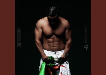 Los romances más icónicos de Penélope Cruz que no te puedes perder en una fotografía de torso masculino musculoso sobre fondo oscuro sujetando una tela verde y blanca.