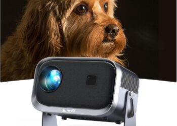 Proyector, 【±360° Rotación/Enfoque Remoto Corrección】 Proyector Portatil 18000L FHD 1080P Mini Proyector, Jimveo WiFi6 Bluetooth Proyector Portátil 4K Soporte Cine en Casa para iOS/Android/HDMI/USB en primer plano con lente iluminada proyectando la imagen de un perro marrón sobre pantalla curva