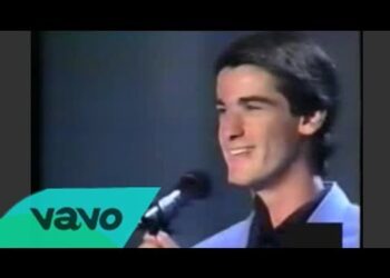 Dónde vive Jesulín de Ubrique: descubre su lujosa residencia, joven sonriente frente a un micrófono sobre un escenario con fondo oscuro.