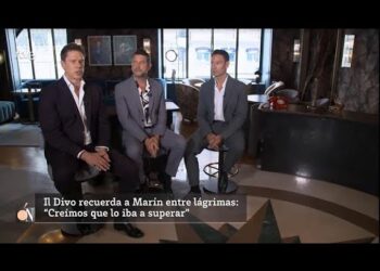 Tres hombres vestidos de traje sentados en un interior elegante durante una entrevista, mostrando una puesta en escena profesional y sobria; Il Divo: Descubre de dónde son los talentosos integrantes del cuarteto.