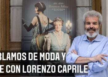 Descubre dónde vive Lorenzo Caprile y su sorprendente historia: entrevista sobre moda y cine frente a un póster de Downton Abbey.