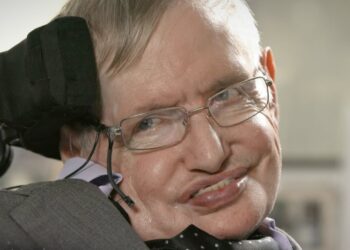 Hombre mayor en silla de ruedas con gafas sonriendo de cerca