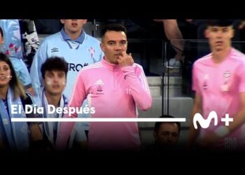 El sorprendente sueldo de este jugador que pocos conocen: futbolista con camiseta de calentamiento rosa junto al banquillo en un estadio