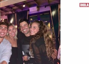 Familia sonriente posando en un restaurante con ambiente nocturno y luces cálidas