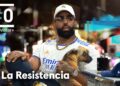 Hombre con gorra blanca, gafas y cadena sentado en el plató de La Resistencia con camiseta blanca con imagen de perro