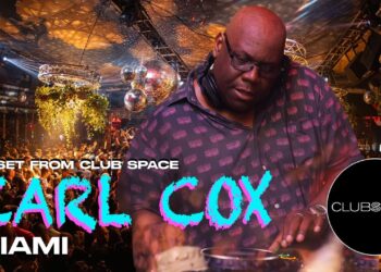DJ en cabina de club nocturno con multitud y bolas de espejos, descubre su impacto y ganancias en el mundo del DJing
