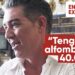 Hombre en perfil durante una entrevista en interior con texto superpuesto que dice 'Tengo una alfombra de 40.000€' y rótulo 'Entrevista exclusiva', expresión sonriente y ambiente doméstico
