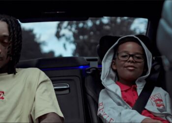 Hombre adulto y niño sentados en la parte trasera de un coche, retrato de viaje familiar sin identificación de las personas