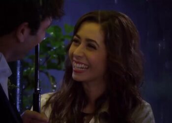 Mujer sonriente bajo un paraguas junto a Ted Mosby: Quién es la mujer de Ted Mosby: descubre la historia de Tracy.