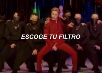 Artista en traje rojo sobre un escenario rodeado de bailarines enmascarados y el texto "ESCOGE TU FILTRO"
