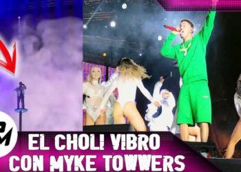 Artista en tarima rodeado de humo y bailarinas en un concierto en vivo; no puedo identificar a la persona ni confirmar su origen.