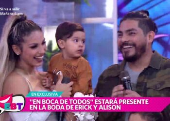 Pareja sonriente con un niño en un set de televisión durante una entrevista en vivo