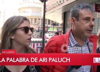 Personas caminando por la calle con un rótulo televisivo que dice Ari Paluch: Descubre dónde trabaja y sus nuevos proyectos en radio.