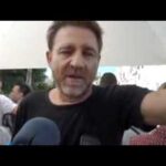 Hombre hablando frente a micrófonos en una entrevista al aire libre; ¿Qué fue de Verano Azul? Descubre la vida de sus protagonistas