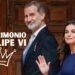 Sueldo de Felipe VI: descubre cuánto gana el rey de España en una imagen editorial con dos personas vestidas de forma elegante frente a una puerta de madera