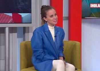 Mujer en plató televisivo con chaqueta azul sentada en sillón verde, Familia Dupeyron: Descubre la historia detrás de sus artistas