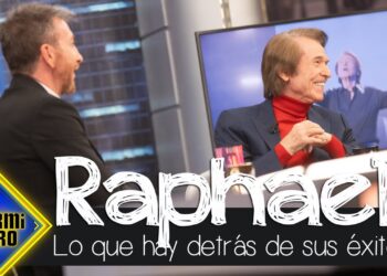 Artista sentado sonriendo en un plató de televisión con el logo de El Hormiguero y El caché de Raphael: descubre cuánto cobra por sus conciertos