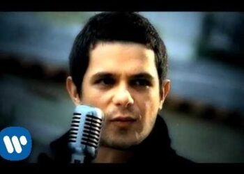 Cantante masculino en primer plano frente a un micrófono vintage, interpretación intensa y mirada concentrada