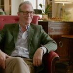 Hombre mayor sentado en un sillón rojo en una sala clásica, La casa de la infancia de la princesa Diana sufre un ataque de vándalos y la familia queda boquiabierta