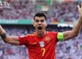 Delantero de la selección española con camiseta roja y brazalete celebrando, Sueldo del futbolista: descubre su fortuna y cifras impactantes