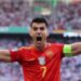 Delantero de la selección española con camiseta roja y brazalete celebrando, Sueldo del futbolista: descubre su fortuna y cifras impactantes