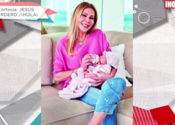 Mujer adulta sentada en sofá alimentando a un recién nacido con biberón