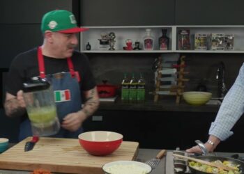 Cocina con dos personas preparando alimentos y compartiendo momentos en un ambiente familiar del chef