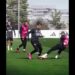Jugadores en entrenamiento en campo de fútbol, regate y entrada durante ejercicio táctico