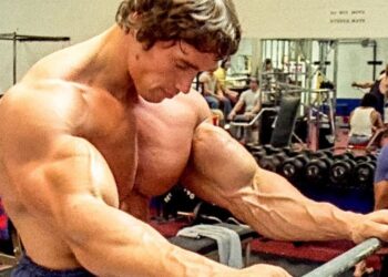 Hombre musculoso entrenando en gimnasio sosteniendo una barra, imagen ideal para ilustrar artículos sobre patrimonio y riqueza de celebridades