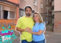 Descubre dónde vive MikelTube y sorpréndete con su hogar: pareja sonriente delante de un bloque de pisos urbano con grafitis y reja de entrada.