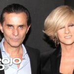 Pareja elegante posando en un evento televisivo con el logo de Telemundo y el rótulo 'Al Rojo Vivo' visibles.