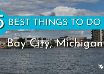 Panorámica del frente marítimo de Bay City, Michigan con texto promocional de actividades y logo; ¿De dónde es Madonna? Descubre su origen y legado musical.