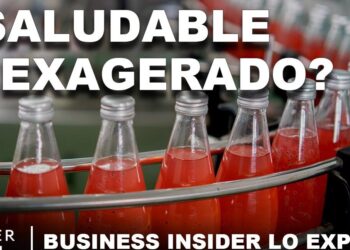 Botellas de bebida roja en una línea de producción con tapones metálicos y texto que cuestiona su salubridad; Descubre por qué este neurocientífico te recomienda cambiar tu café por champiñones y transforma tu salud ahora mismo