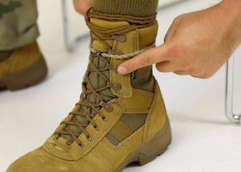 Descubre cómo el regreso del boot tuck de los 2000 transformará tu look este otoño 2025 en una bota militar color camel con cordones, ganchos metálicos y un dedo señalando el ajuste del tobillo