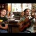 Dos músicos tocando guitarras en un bar con ambiente íntimo; Caché de Estopa: Descubre cuánto cobran por sus conciertos