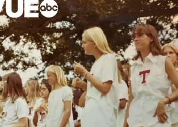 Grupo de niñas y adolescentes con camisetas blancas reunidas al aire libre, evocando una escena de campamento veraniego y camaradería.