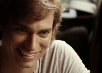 Retrato en primer plano de un hombre joven sonriendo con luz cálida, mirada cercana y ambiente íntimo; Descubre dónde vive Carlos Baute: su hogar y estilo de vida