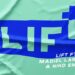 Tela verde con logotipo azul LIFT, texto de colaboración y marca Carlos Herrera; Dónde trabaja Carlos Herrera: descubre su trayectoria y proyectos.