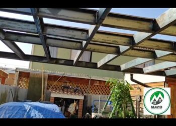 Descubre la Casa de Fierro en Iquitos: historia y encanto único en un patio con estructura metálica, vigas a la vista y detalles tradicionales.