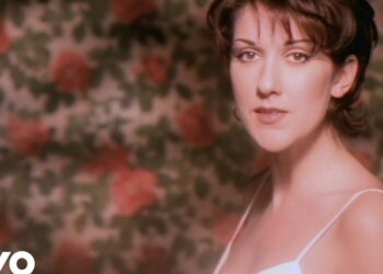 Retrato íntimo de una cantante en primer plano frente a un papel tapiz floral, Dónde vive la cantante: descubre su hogar y estilo de vida.